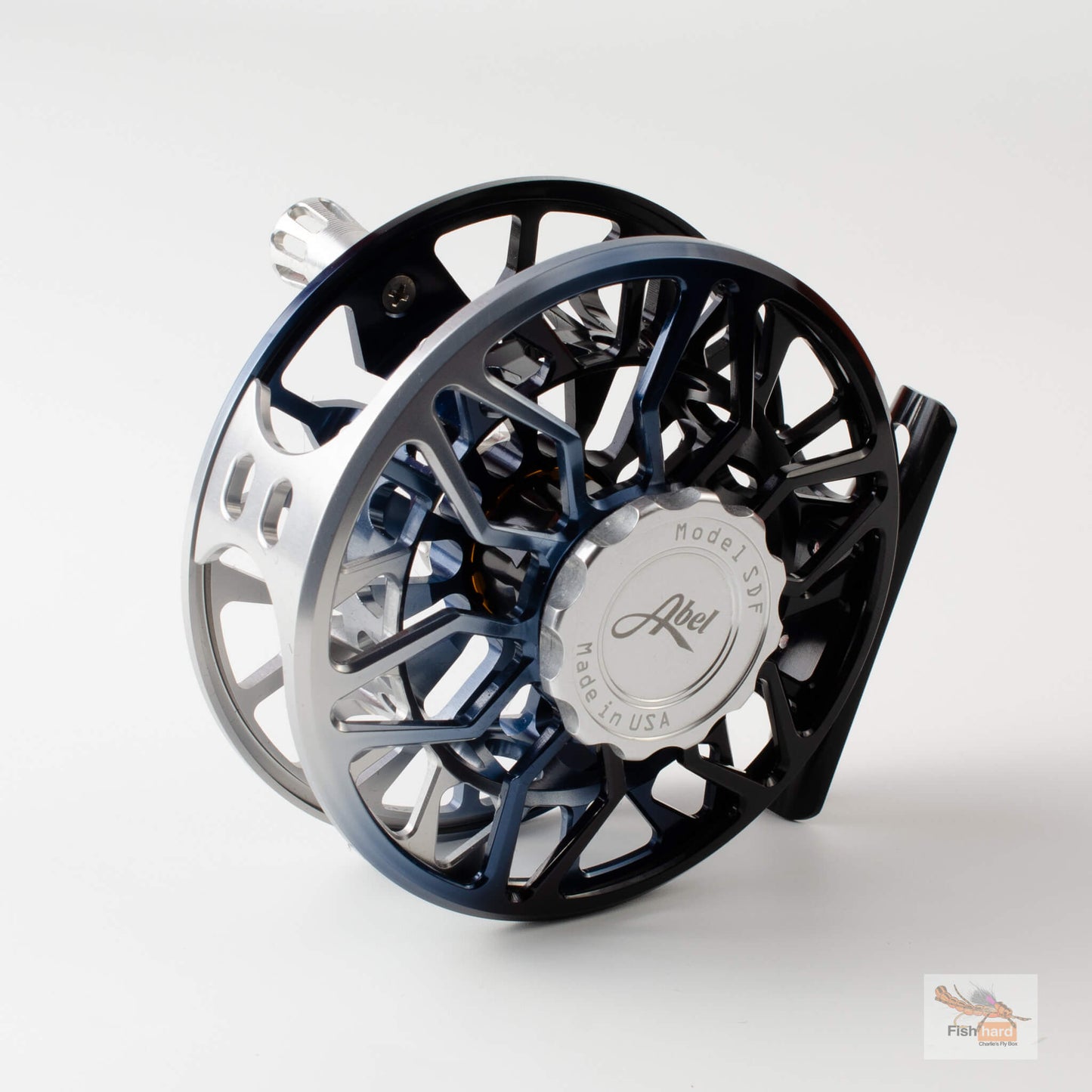 A close-up studio shot of a fly fishing reel, showing its black and blue anodized frame, silver spool, and a silver central cap with the 'Allee' brand logo.
