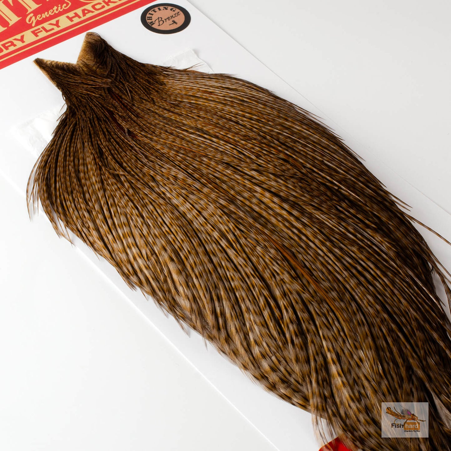 Dark barred ginger dyed dun Whiting rooster cape with a red and white label.