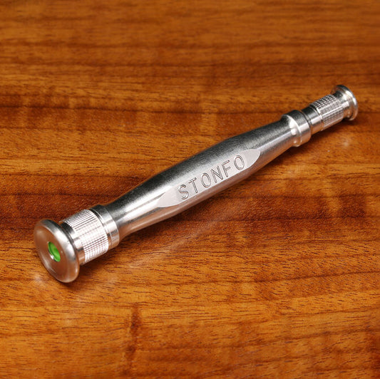 A silver metal hand tool engraved with the brand name 'STONFO' resting on a warm brown wooden surface.